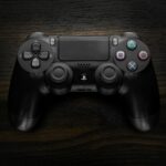 High-resolution image of a Sony DualShock 4 game controller against a dark wooden background.